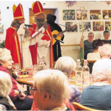 Was wohl im Buch stand? - Der Samichlaus besuchte auch die Seniorinnen und Senioren im Altersheim St. Martin. Was zu allerlei Schmunzeln führte. Bild: zg