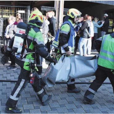 E-Autos einfach löschen - Der Atemschutztrupp demonstriert eine Rettung aus dem «brennenden» Haus. Bild: Verena Anna Wigger