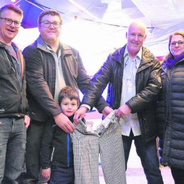 Etwas für die Gemächlichen - Die Bäckerhosen sind offiziell übergeben: Roger Wyss und Thomas Fischer (von links) nehmen ihre Arbeitskleider von Daniel und Elsbeth Bütler entgegen. Bezeugt wird dies von Fischers Sohn Magnus. Bild: Celeste Blanc