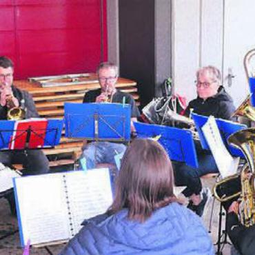 Wald der mystischen Skulpturen - Zur Jubiläumsfeier des Skulpturenwegs spielt unter dem Vordach des Schulhausplatzes der Musikverein Dietwil auf.