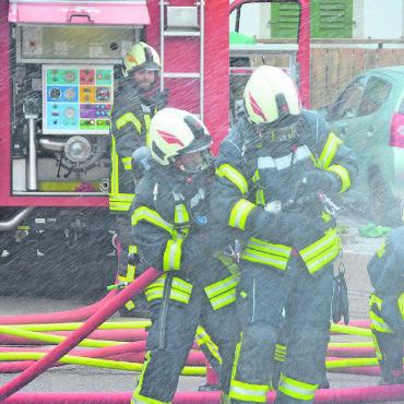 Baby aus dem Auto retten - Das Bild täuscht. Geregnet hat es nicht, nass wurden die Feuerwehrleute trotzdem.