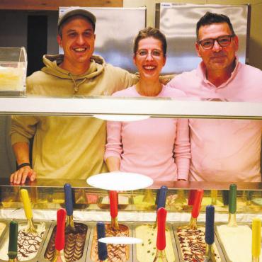 Gute Ergänzung zu Delikatessen - Sie dürfen sich über das gelungene Projekt freuen: (v. l.) Manuel Staubli, Katrin Bürkli und Luigi Spina, Geschäftsführerpaar, hinter der verlockend gefüllten Glacevitrine. Bild: vaw
