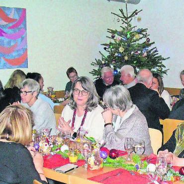 Weihnachtsfest für alle - Ein Blick auf die fröhliche Gästerunde der Weihnachtsfeier in der Synesiusstube mit dem traditionellen Christbaum und der liebevoll gestalteten Tischdekoration. An Heiligabend ist hier jeder willkommen. Der Pastoralraum knüpft mit der Feier an das langjährige Angebot im einstigen Centro Italiano von Armando Caravetta an. Bild: Alphonse Hauser