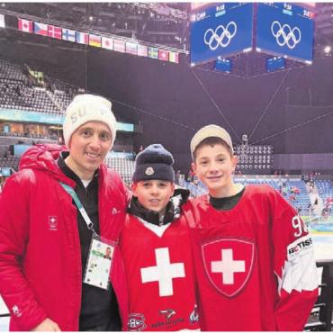 «Wir sind bereit für Olympia» - Pascal Jenny mit Kids in der riesigen Olympia-Eishalle. In der Mitte sein Sohn Diego mit einem Teamkollegen vom HC Davos (rechts). Bilder: zg