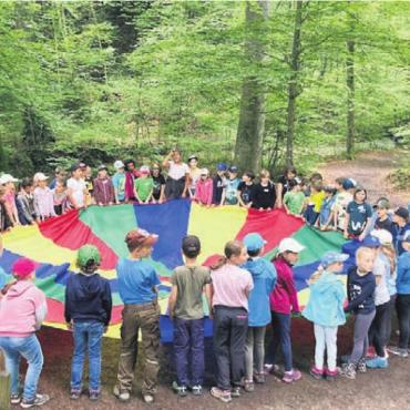 Kennenlernen und kreativ wirken - Gegenseitiges Kennenlernen beim Spiel mit dem grossen runden Segeltuch beim Waldsofa in Benzenschwil. Bild: zg