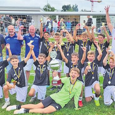 Die Besten mögen gewinnen - Die Sieger-Mannschaft von 2022 des FC Sins mit Trainerteam, flankiert von Reto Hübscher (links), Leiter der Raiffeisenbank Reuss-Lindenberg, sowie Rolf Thumm (rechts), Generalagent, die Mobiliar, Freiamt. Bild: zg