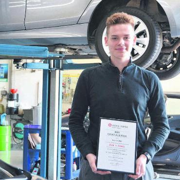 Nicht nur beruflich hohe Ziele - Umgeben von Autos und mit dem Diplom in der Hand: Ivan Haller, Lernender der Garage Maeder in Merenschwand. Bild: Annemarie Keusch