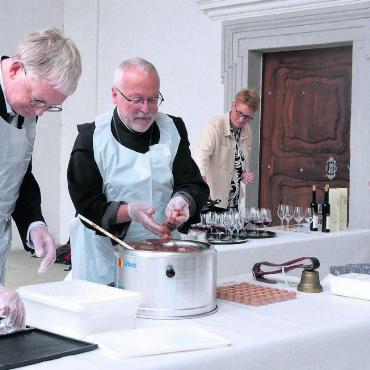 Bsetzi-Steine zum Genuss - Peter Hochuli, Präsident der Freunde der Klosterkirche, und Abt Peter Stuefer im Einsatz. Regula und Buki Kreyenbühl (von links) beobachten ihr Wirken. Die Idee der süssen Kloster-Bsetzi-Steine kommt von ihnen. Bild: Annemarie Keusch