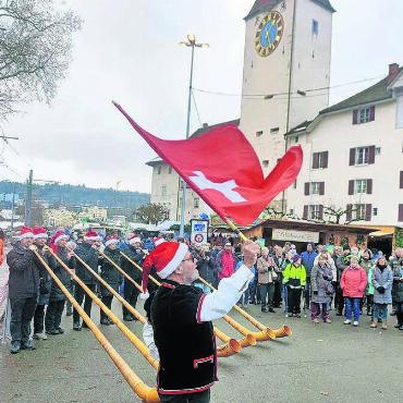 Leuchttürme sein - Alphornklänge inkl. Schweizerfahne vor Schaulustigen unter dem Spittelturm.