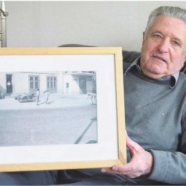 Viele Autos als Zeichen der Freiheit - Anton Kobler mit einem alten Bild, das ihn als Buben vor der Tankstelle seines Vaters an der Zürcherstrasse zeigt. Bilder: zg / Annemarie Keusch