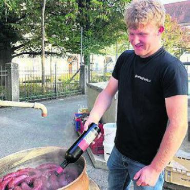 Anstossen auf ein rundes Jubiläum - Rotwein in den Sud gibt den Treberwürsten ihr spezielles Aroma.