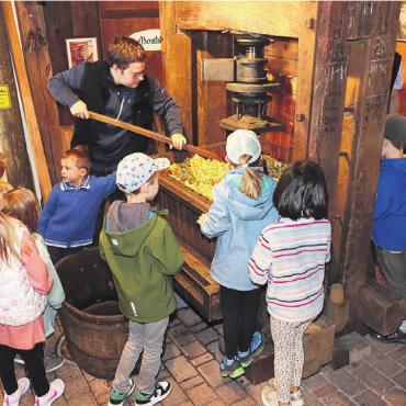 Das Handwerk des Mostens - Staunende Kinder beim Mostpressen. Bild: zg