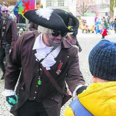 «Fasnacht macht Freude» - Doch auch süsse Gaben kommen nicht zu kurz. Diesen Buben beglückt der Stubenmeister der Schpitelturm-Clique höchstpersönlich.