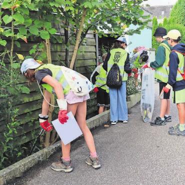 Wenig Arbeit für die «Dorfputzer» - Mit dem Blick hinter die Hecken und in die Beete finden die Schülerinnen und Schüler alles, was nicht von der Natur kommt.