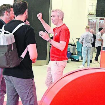 Grosser Stolz über das Erreichte - Geschäftsführer Chris Mühlemann (wie das gesamte Personal im roten T-Shirt) freut sich über das grosse Interesse und führt einen Teil der Kunden persönlich durch das Gebäude.