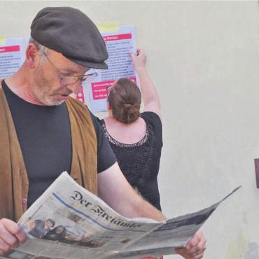 Auf dem Krimitrail durch Muri - Stefan Staubli, Präsident vom Muri Energie Forum, liest in der Rolle von Max Koller in der Zeitung über sich und die vier anderen Tatverdächtigen. Bild: Thomas Stöckli