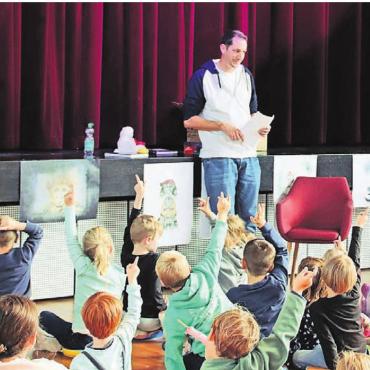 Bilder in Worte verwandeln - Startschuss für die Kleinsten: Autor Stefan Sprenger liest den 40 Kindern (und 50 Begleitpersonen) aus seinem Kinderbuch «Chnorrlimorrli» vor. Bild: Adrian Humbel
