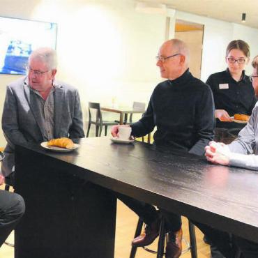 Treffpunkt im Dorf schaffen - Die Serviceangestellten des «Hans & Heidi», Olivia Ingold (links) und Alina Mehovic, servieren den Verantwortlichen des Projekts gekonnt einen Kaffee (von links): Walter Küng (Präsident Integra), Hansueli Pfyffer (Mitglied Kirchenpflege), Josef Brunner (Präsident Kirchenpflege), Markus Loher (Präsident Baukommission), Marcel Meyer (Leiter Arbeit Integra), und Jonas Meier (Geschäftsführer Integra). Vielleicht arbeiten die beiden Frauen schon bald im neuen Café Hoi. Bilder: Chregi Hansen