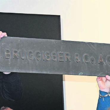 «Mir geht jedes Mal das Herz auf» - Immerhin das Firmenschild des Unternehmens Bruggisser & Co konnte gerettet werden: Daniel Güntert und Corina Haller, die das Zeitzeugen-Gespräch führten, präsentieren das seltene Stück.