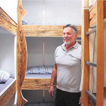 Alpenhüttenflair auf Rädern - André Ott in einer der heimeligen Schlafkabinen. «Unser Ziel war es, eine flexible und komfortable Unterkunft zu schaffen, die bei verschiedensten Veranstaltungen zum Einsatz kommen kann», sagt er. Bilder: Monika Rast / zg