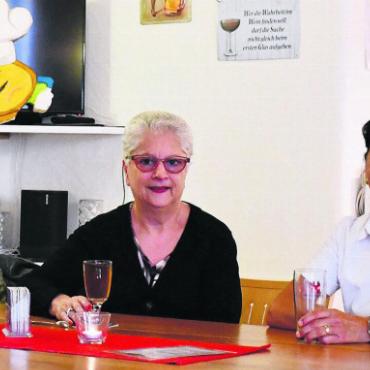 «Wir sind mega glücklich da» - Jacky Brumann, weisse Bluse, und Rolf Kopf, rechts, nehmen sich die Zeit, mit ihren Gästen zu plaudern. Dieser vertraute und freundschaftliche Umgang wird ihnen künftig fehlen. Bild: Verena Anna Wigger