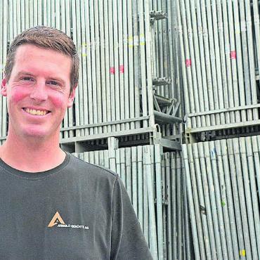 Von 2 auf 15 in zehn Jahren - Matthias Arnold vor ganz vielen Gerüstbau-Elementen. Bild: ake
