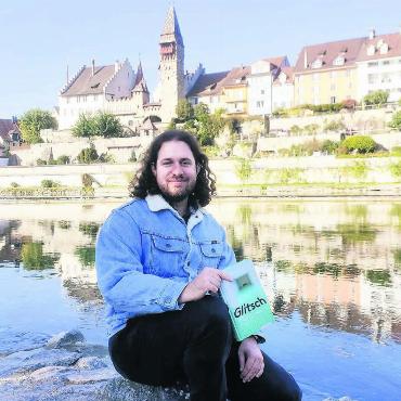 «Bremgarten hat mich geprägt» - Florian Oegerli mit seinem Roman an der Reuss vor der Bremgarter «Schoggiseite». «Manchmal vergesse ich, wie schön es hier ist, und bin von Neuem wieder regelrecht verzaubert», sagt er über das Städtli seiner Kindheit. Bild: Marco Huwyler
