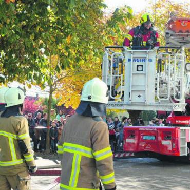 Eine Trychle zum Abschluss - Eine steigunfähige Person wird per Autodrehleiter gerettet. Feuerwehrleute nehmen diese in Empfang.