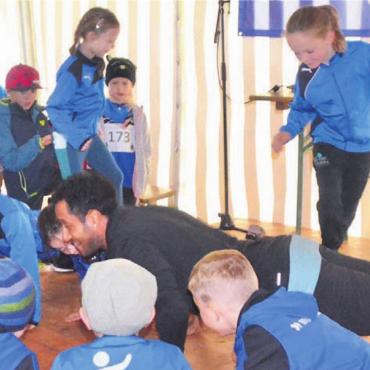 Aufwärmen mit dem Sprint-Profi - Für einen Spass zu haben: Sprinter William Reaid legt mit den Kindern spontan eine Liegestütz-Session ein. Bilder: Thomas Stöckli