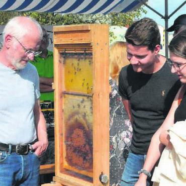 Etwas Wunderbares entstanden - Markus Müller (links) spricht mit zwei Interessierten über die Bienen im Schaukasten.