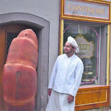 Action trotz Regentropfen - Confiseur: Wieder und wieder musste Confiseur Cavelti sein grosses Werbegipfeli vor dem Eingang seines Ladens umplatzieren, bis die Regisseurin zufrieden war.