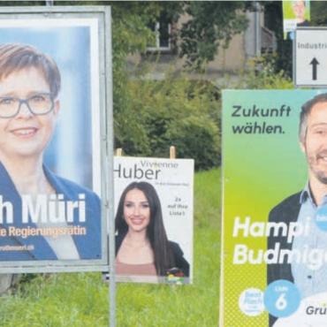 Der achte Sitz im Fokus - Freundlich lächeln aktuell zig Politikerinnen und Politiker vom Strassenrand. Bild: ake