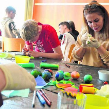 100 Eier verbinden Kulturen - Gross und Klein macht sich mit viel Einsatz, Konzentration und Kreativität daran, hundert Eier zu färben. Bild: Annemarie Keusch