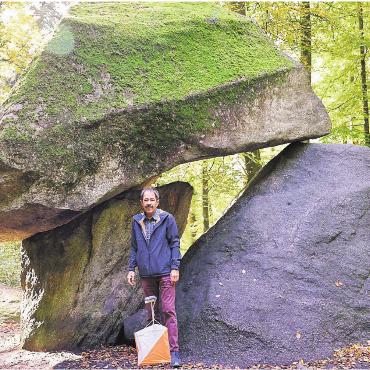 Durchblick beim Erdmannlistein - Valentin Brunner, Laufleiter der SM im Team-OL, vor dem Erdmannlistein. Die Beschreibung der OL-Strecke lautet gemäss Ausschreibung wie folgt: «Coupierter Mittellandwald mit wechselnder Vegetation. Offene, sehr gut belaufbare Gebiete wechseln sich mit mystischen Waldpartien und einigen dichteren Stellen ab.» Bild: zg