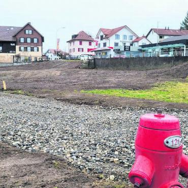 Weg frei für neue Überbauung - Das Areal liegt direkt neben der Kantonsstrasse, aber leicht abgesenkt. Zwei Gebäude entlang der Strasse sollen für den nötigen Lärmschutz sorgen. Bilder: Chregi Hansen / Archiv