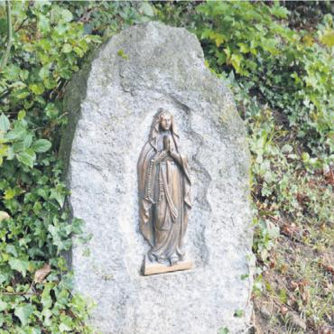 Bittsuchende besuchen die Grotte - Auf dem Weg zum Ort der Stille steht der ehemalige Grabstein von Maria Etterli. Sie ist eine der beiden Stifterinnen der Lourdes-Grotte.