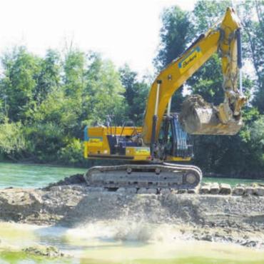 Dreifaches Fest in Sins - Das Reusswasser kommt: Ein Bagger öffnet den Damm zur Reussegg, Sins. Bild: rig