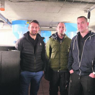 Im Teller der besten Köche - Das Team der Edelkrebs AG umgeben von Becken, in denen Schweizer Äsche und Masu-Lachs heranwachsen, von links: Florian Gemperle (Geschäftsführer), Philipp Flatau und Christian Rüttimann (beides Mitarbeitende). Bild: Annemarie Keusch