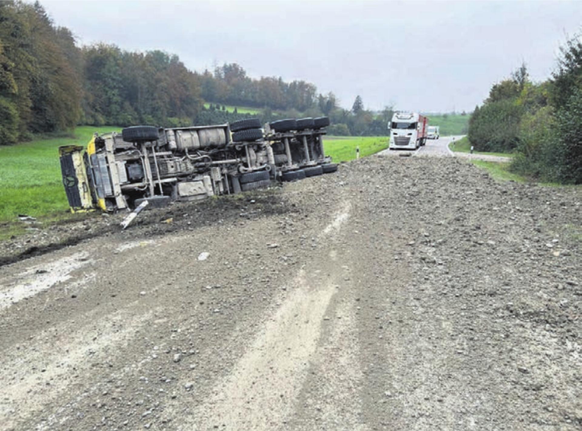 Kies und Geröll auf der Strasse, der Muldenkipper umgekippt daneben. Bild: pz