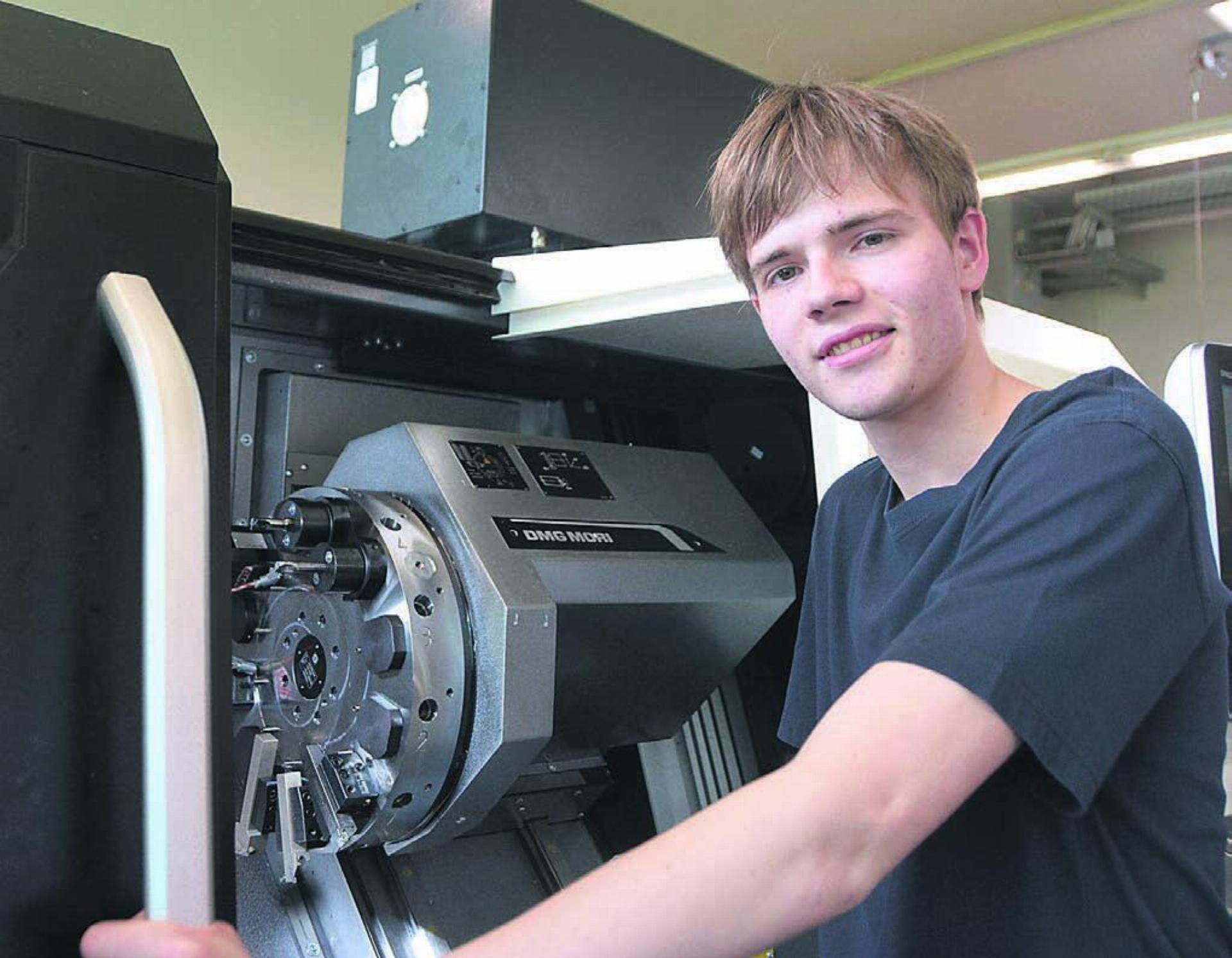 Thomas Veidt an der CNC-Drehmaschine, die sein Arbeitgeber extra für ihn früher als geplant angeschafft hat. Bild: Annemarie Keusch