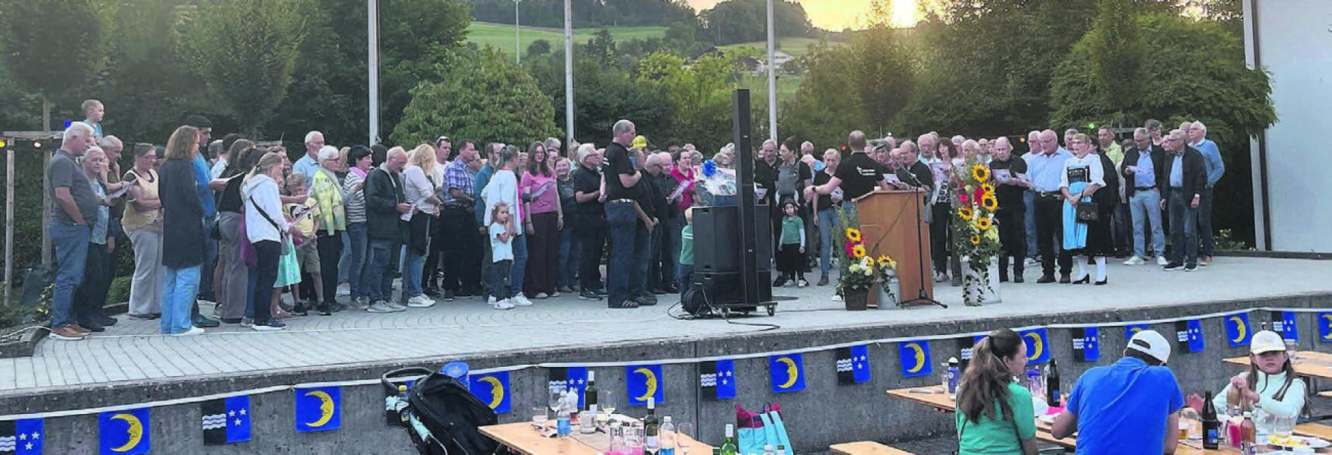 Quasi leere Bänke im Publikum, stattdessen eine volle Bühne. Gemeinsam sang der organisierende Jodlerclub Echo vom Lindenberg mit der Bevölkerung die Nationalhymne. Bilder: mub - Das Bild wird blockiert. – Möglicherweise durch einen aktiven Adblocker.