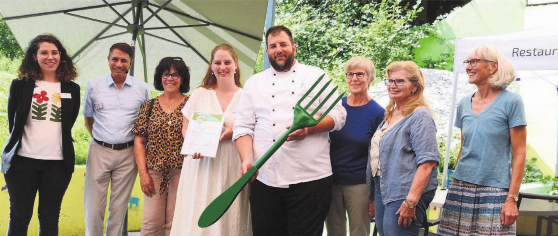 Beatrice Meier Wahl vom Landwirtschaftlichen Zentrum Liebegg (rechts) überreicht Küchenchef Reto Bussmann und Restaurantleiterin Belinda Marcella (Mitte) das Zertifikat und die Fourchette verte (grüne Gabel) im Grossformat. Mit dabei die Verantwortlichen der Oberen Mühle und ein Teil der Fahrerinnen. Bilder: Chregi Hansen