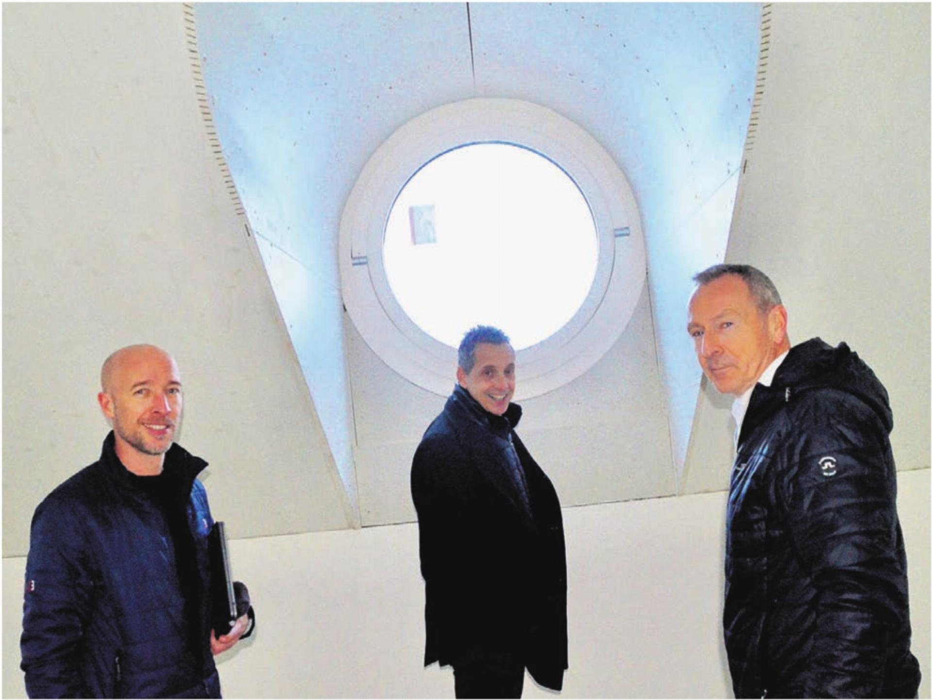 Ein prägendes Element sind die Rundfenster im Dachgeschoss des Wohnhauses. Sie nehmen Bezug auf den nahen Kirchturm. Von links: Bauleiter Thomas Zürcher, Reto Schoch, Leiter der Baukommission, und Bankleiter André Bächinger. Bild: Thomas Stöckli - Das Bild wird blockiert. – Möglicherweise durch einen aktiven Adblocker.