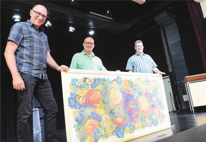 Die drei Verantwortlichen (von links: Bauleiter Kurt Leuppi, Verwalter Andy Bächer und Präsident Paul Huwiler) mit dem Gemälde, welches während der ganzen Bauzeit immer irgendwo auf der Baustelle stand. Bilder: Chregi Hansen / zg