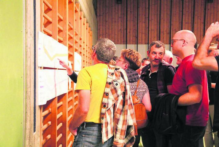 Die aufgehängten Pläne werden von den Anwesenden genaustens studiert. Nicht alle haben Freude am Projekt. Bild: Monica Rast