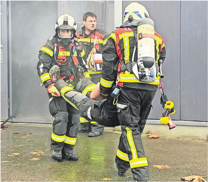 Die Atemschutzgruppe rettet eine Person aus der mit Rauch gefüllten Produktionshalle. Bilder: Walter Minder Die Atemschutzgruppe rettet eine Person aus der mit Rauch gefüllten Produktionshalle. Bilder: Walter Minder