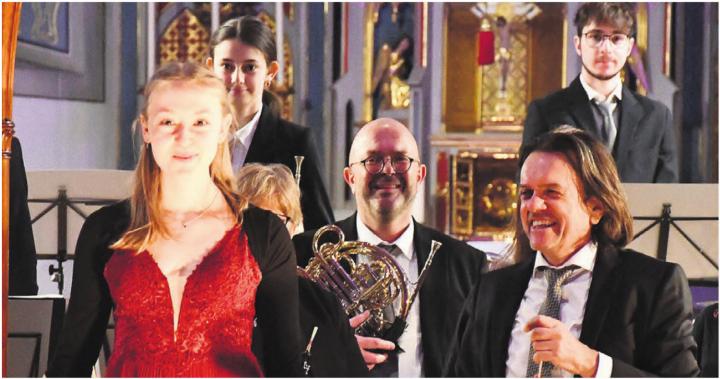 Solistin Jana Bürger begeistert die Zuhörer an der Harfe. Für sie ist es ein besonderes Erlebnis, mit der Musikgesellschaft zu spielen. Auch Peter Werlen (rechts) und die Musikgesellschaft freuen sich über die erbrachte Leistung. Bild: Monica Rast