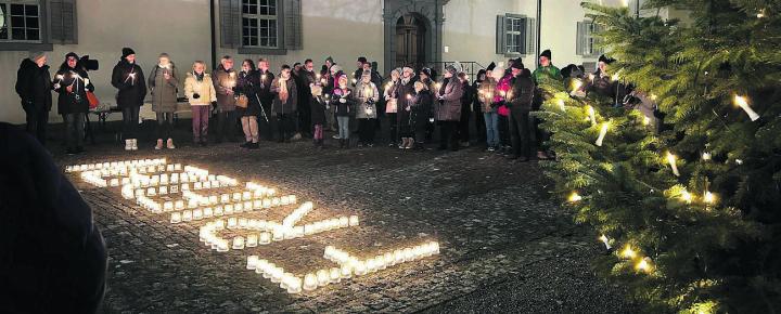 Was sich nicht nur zu Weihnachten viele wünschen, steht gross vor der Klosterkirche: Frieden. Die Friedenslicht-Andacht des Pastoralraums war ein stimmungsvoller Anlass. Bilder: Annemarie Keusch