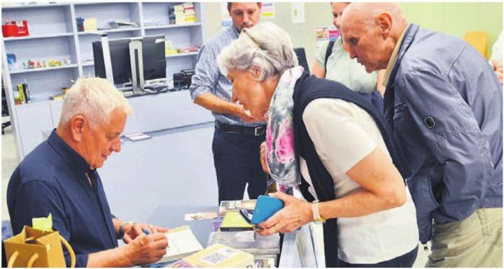 Röbi Koller (links) nimmt sich Zeit für die Autogrammwünsche seiner Leser. Bild: tst