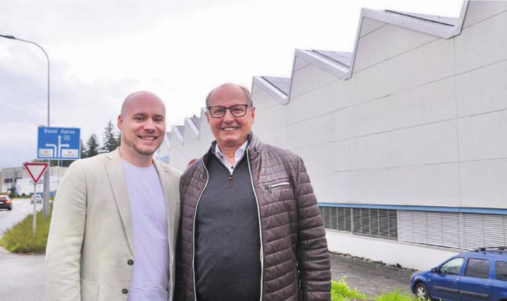 Adrian Trottmann (links), Inhaber Profilpress, und Josef Nietlispach vor dem sanierten Sheddach mit PV-Anlage. Bilder: Thomas Stöckli / zg